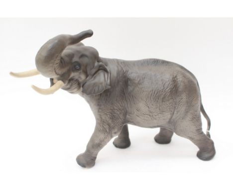 A Beswick large Elephant with trunk in salute (one tusk replaced) 