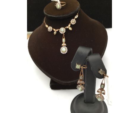 A Continental yellow metal suite comprising pair of drop earrings a ring and a necklet with drop details, set with cat's eye 