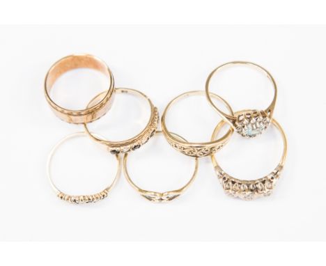 A collection of seven 9ct gold rings, to include a three stone diamond ring, a sapphire and white stone wish bone ring and a 