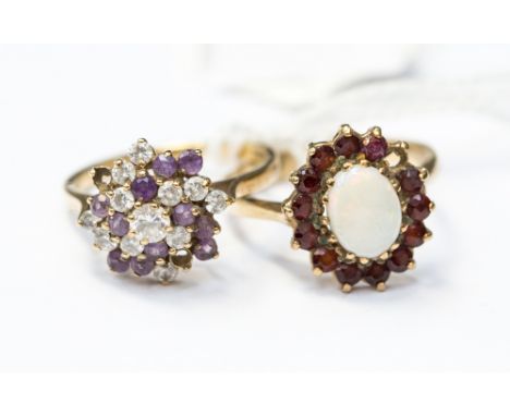 Two 9ct gold stone set dress rings, comprising an opal and garnet cluster ring, (af) stone missing, along with a lilac and wh