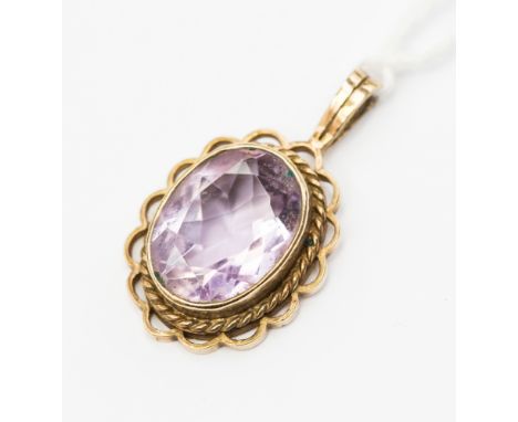 An amethyst and  9ct gold pendant, comprising an oval amethyst approx, with a rope edge and open work scalloped border,  ston