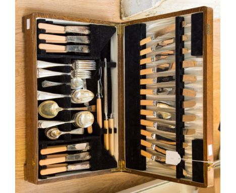 An early 20th Century oak cased canteen of cutlery containing six place settings, including dinner knives and forks, fish kni