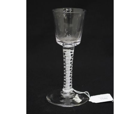 An 18th Century opaque twist wine glass, the bucket bowl on double stand and lattice core stem, conical foot, 5.2 cm rim, 7 c