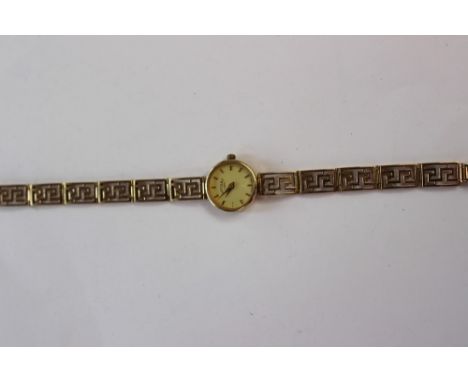 A 9ct gold ladies Rotary wristwatch, round cream  enamel dial with batons, diameter approx 15mm, with an aztec key style stra