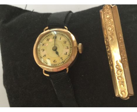 A circa 1920's 9ct gold and mother of pearl ladies watch with ribbon strap,  along with a yellow metal bar brooch