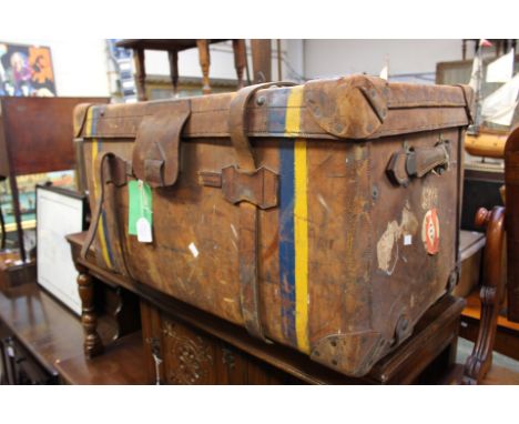 An early 20th Century canvas and wood bound travelling trunk, together with a brown leather travelling trunk, both bearing or