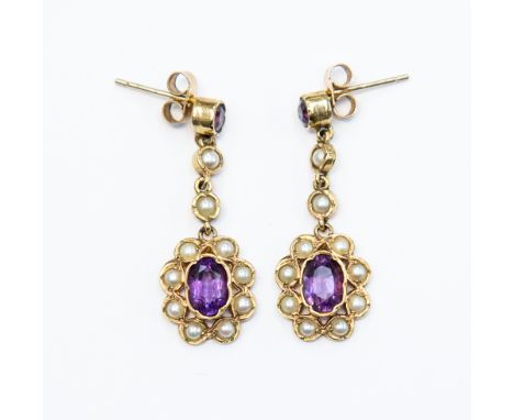 A pair of amethyst and cultured pearl earrings set in 9ct gold, with a single stone amethyst to the top, with pearl detail to