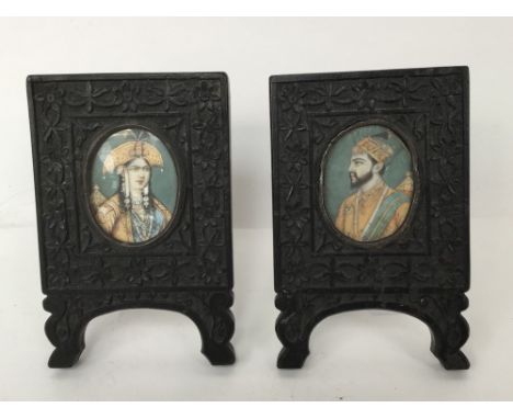 A pair of 19th Century Anglo Indian portrait miniatures in carved ebony frames