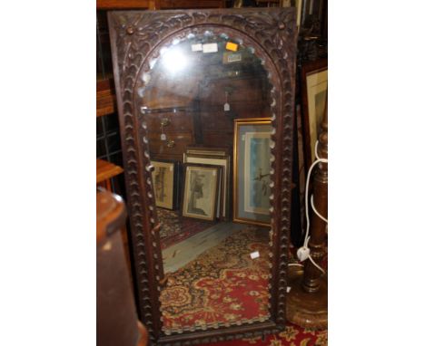A large oak framed mirror with floral carving to top, approx 52 x 112 cm 