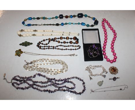 A box of costume jewellery to include bead necklaces, jade coloured brooch, amethyst set brooch etc. 