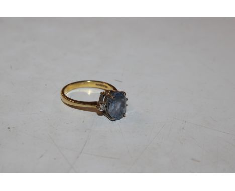 An 18ct gold ring set with coloured stone, flanked by two diamonds, 4.2gms total weight, ring size N/O