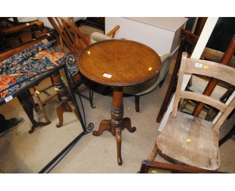 An oak plant stand with circular top and tripod base