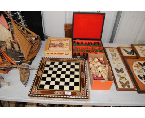An inlaid chess board, two sets of resin chess pieces, a Bagatelle board and a Monopoly set