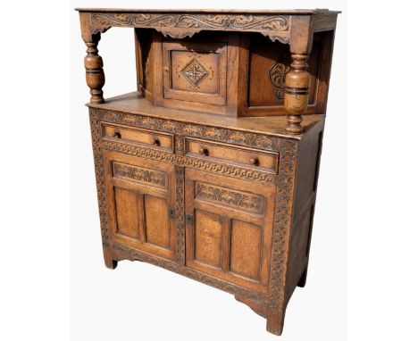 Charles II style oak court cupboard with scroll carved cornice on baluster turned supports, two moulded panel drawers above a