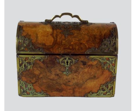 A Victorian figured walnut gothic style dome top tea caddy, the hinged lid with pierced brass strapwork, under a loop handle 