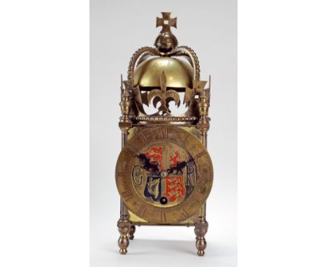 A commemorative brass lantern clock, the 4 1/2 inch brass dial centred with an engraved coat of arms for George VI to commemo