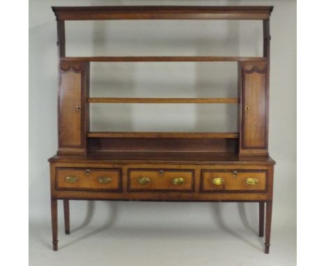 A George III oak crossbanded mahogany Shropshire dresser, the three shelf rack with tall narrow side cabinets on a three draw