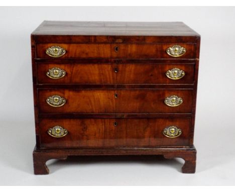 A George III mahogany chest of four long graduated drawers, the rectangular top with crossbanded border, over the four cockbe