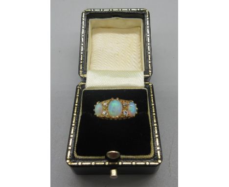 18ct yellow gold opal and diamond ring, the three cabochon opals separated by brilliant cut diamonds, stamped 18, size G1/2, 