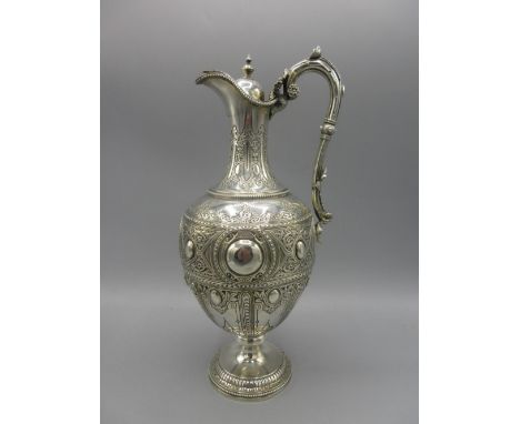 Victorian silver claret jug of baluster form, vacant cartouche, panels of engraved geometric detailing, embossed scrolling an