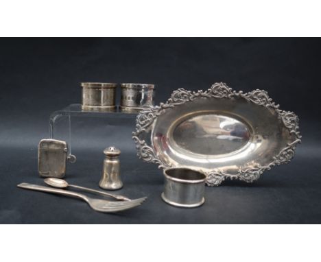 A Victorian silver pin tray of oval form decorated with scrolls and leaves, Birmingham, 1899, together with a silver napkin r