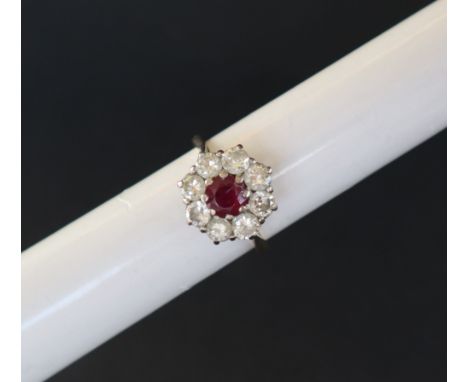 A ruby and diamond cluster ring set with a central ruby surrounded by eight brilliant cut diamonds each approximately 0.10 of