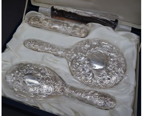 An Elizabeth II silver four piece dressing table set comprising a hand mirror, hair brush, clothes brush and comb, Birmingham