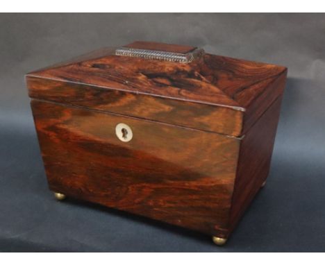 A Victorian rosewood sarcophagus tea caddy, with a reeded top on four brass ball feet, the interior with two lidded compartme