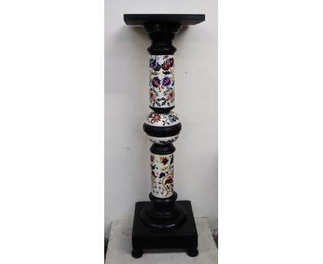 A Zsolnay Pecs pottery and ebonised jardiniere stand with a square top above a floral decorated pottery column on a square ba