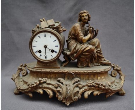 A 19th century ormolu mantle clock, depicting a seated maiden playing a lyre, on an oval scrolling base, the enamel dial with