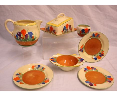 A Clarice Cliff Crocus pattern cheese dish and cover together with a similar jug, three plates twin handled bowl and pot