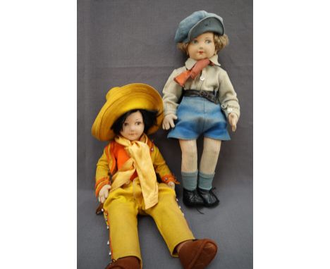 A felt doll with black hair, brown eyes and painted lips dressed as a cow girl, 44cm high together with another dressed as gi
