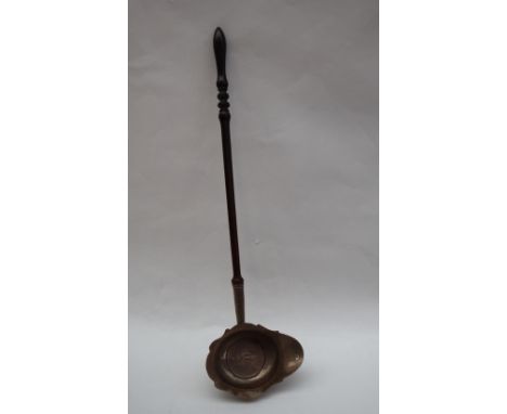 An Irish silver ladle with a pointed oval bowl inset with a 1736 medallion inset on a turned wooden handle 36cm long