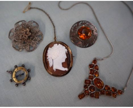 A shell cameo of a figure in profile together with an amber pendant, a Scottish silver brooch of circular form decorated with
