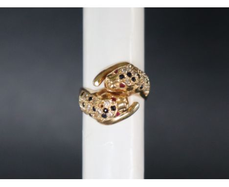 A 14ct yellow gold ring in the form of two leopards heads set with ruby eyes, sapphires and diamonds, size M 1/2, approximate