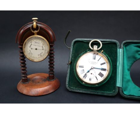 A gilt metal compensated pocket barometer, with a silvered dial, 5cm diameter on a stand together with a Goliath desk clock, 