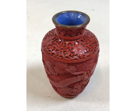 An oriental Cinnabar style  lacquerware vase carved with dragon and foliage with blue enamel base and interior H:13cm