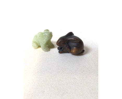 A wooden carved Netsuke of a rabbit, signed to base, also with a carved jade frog W:5cm x D:3cm x H:3cm RabbitW:4cm x H:3cm F