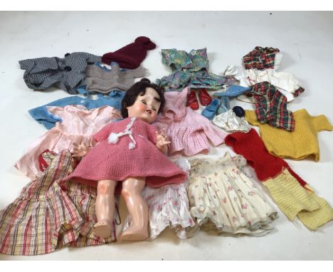 A vintage Pedigre  doll with opening blue eyes and open mouth and quantity of clothes. Head needs reattaching 