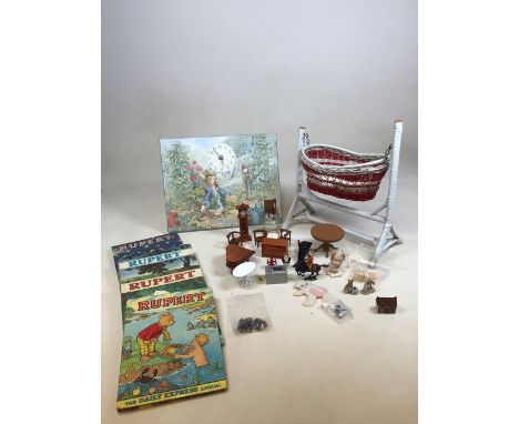Four Rupert annuals form the 1970s, a dolls cot, dolls house furniture, a Peter Rabbit clock and other items 