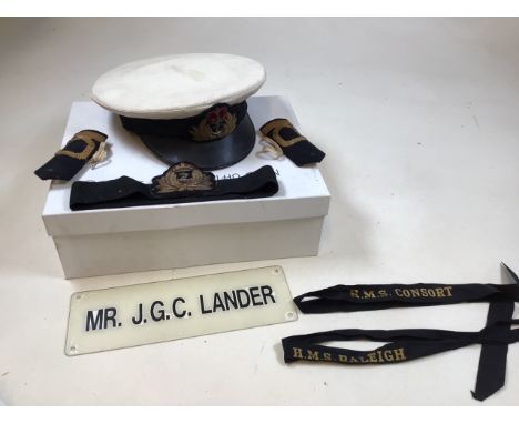 A Royal Naval officers cap belonging to Mr J G C Lander also with epaulettes and another hat band, and 2 ribbons printed with
