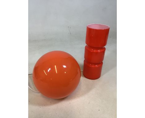 An orange glass retro style Habitat lamp with an orange globe lamp with other items 