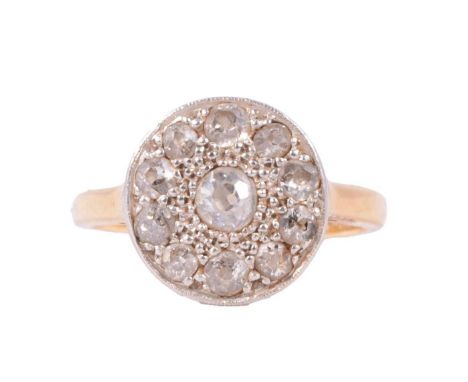 A circular diamond cluster ring, the central old cut stone surrounded by ten old cut stones all claw set in a yellow and whit