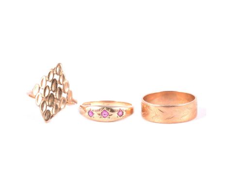 A ruby ring and two gold rings, a ruby ring, the three mixed cut stones gypsy star set in a 9 carat yellow gold mount ring si