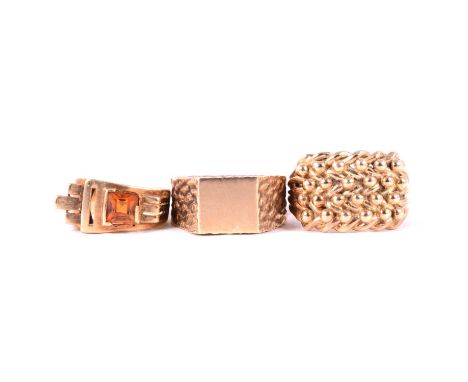 Three 9 carat yellow gold rings, a 14mm wide curb and shot ring size Y, London 1979; a signet ring with rectangular polished 