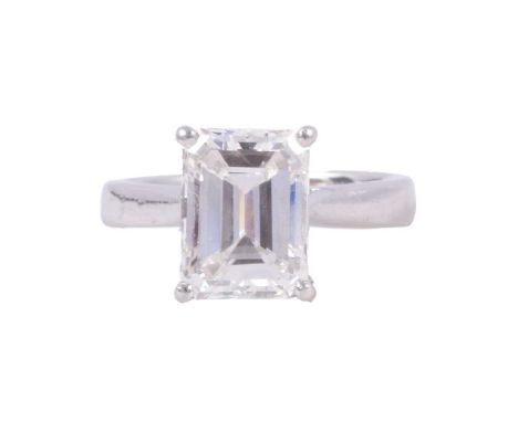 A diamond solitaire ring, the emerald cut diamond, 10.4mm x 7.75mm, four claw set in a platinum mount ring size K½, ten small