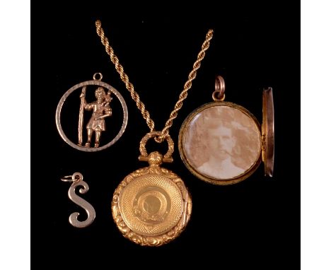 A yellow metal circular locket on a chain, rose metal locket, St Christopher charm pendant and letter S charm, a yellow metal