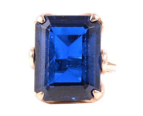 A large deep blue synthetic spinel dress ring, the rectangular step cut stone, 20x15mm, claw set in an all yellow metal mount