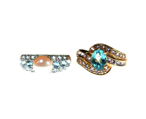 Two gemset rings, a teal and pale purple stone ring, the oval mixed cut teal stone and twenty-six brilliant cut pale purple s