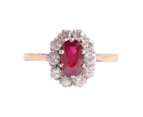 A ruby and diamond cluster ring, the oval mixed cut ruby surrounded by ten brilliant cut diamonds in a yellow and white metal